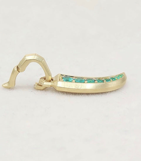 A gold-toned curved earring with a row of small green stones set along the front, photographed on a plain light background.
