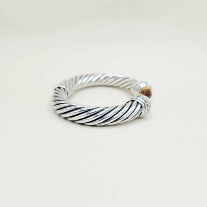 Silver twisted ring on a light beige background