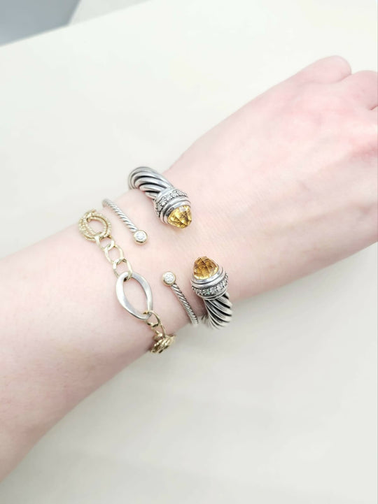 Close-up of a wrist wearing multiple bracelets on a light background