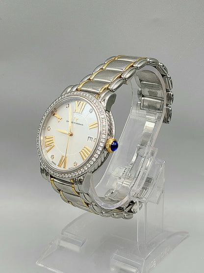 Silver and gold watch on a clear stand with a gray background