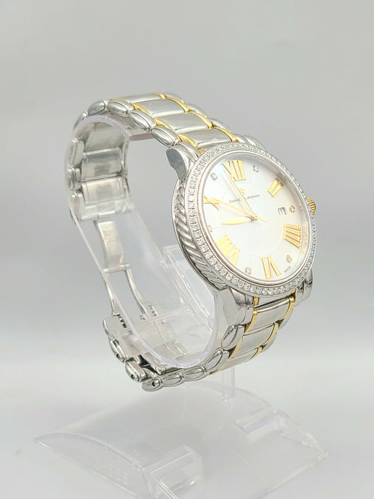 Two-tone watch with silver and gold band on a clear stand against a light gray background