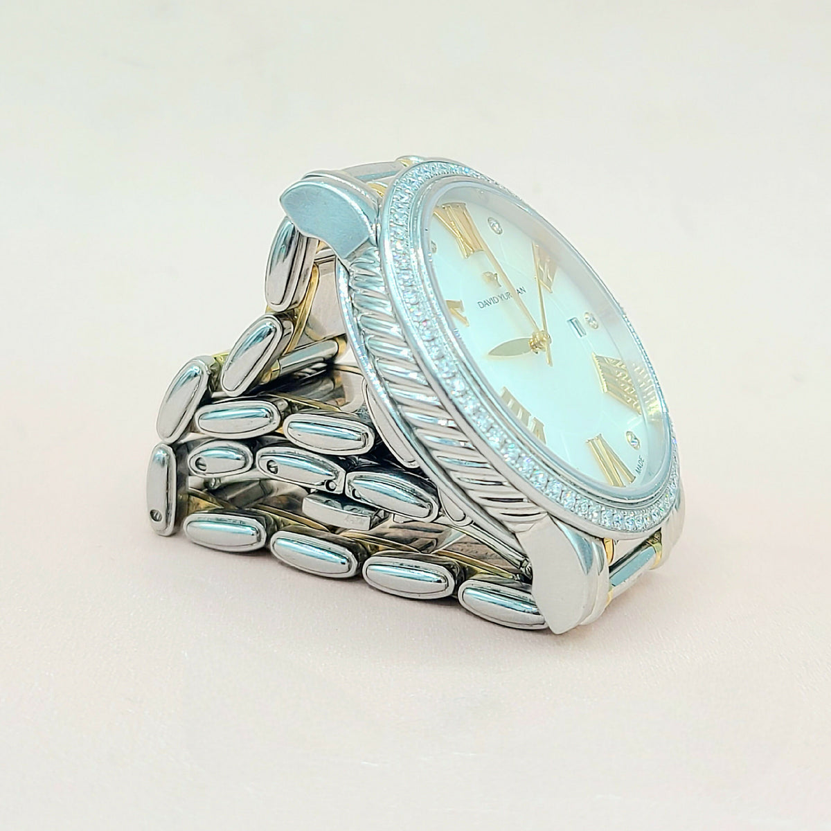 Silver ring with a clock face design on a light background