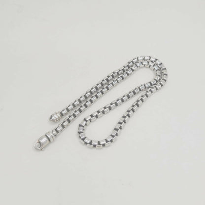 Silver chain on a light gray background
