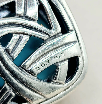 Close-up of a silver ring with 'Q.D.Y. 925' engraving on a neutral background