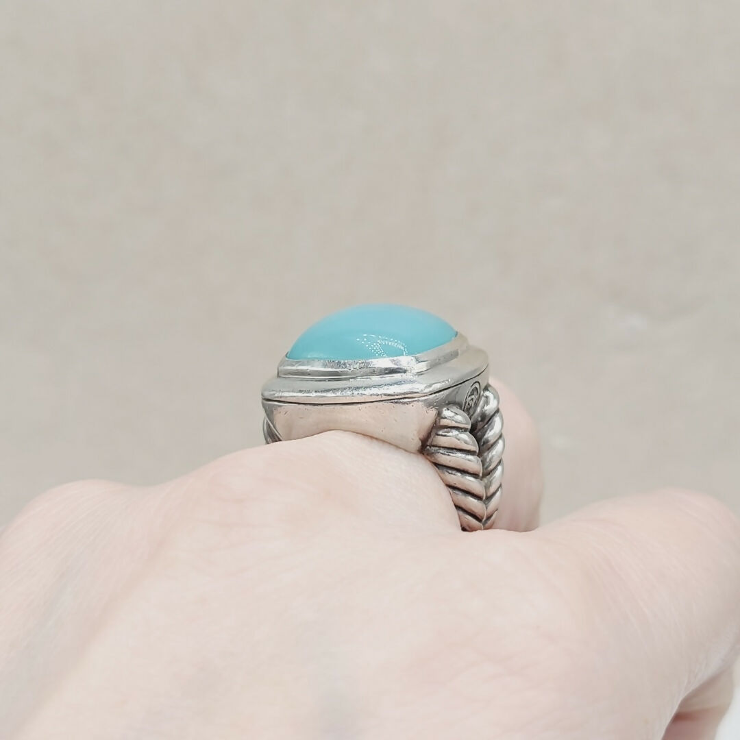 Silver ring with a blue stone on a neutral background