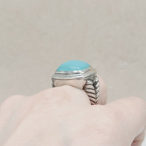 Silver ring with a blue stone on a neutral background