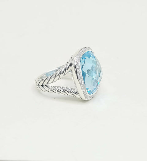 Silver ring with a large blue gemstone on a white background