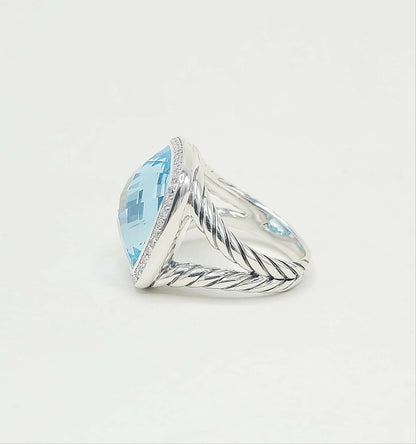 Silver ring with a large blue gemstone on a light gray background