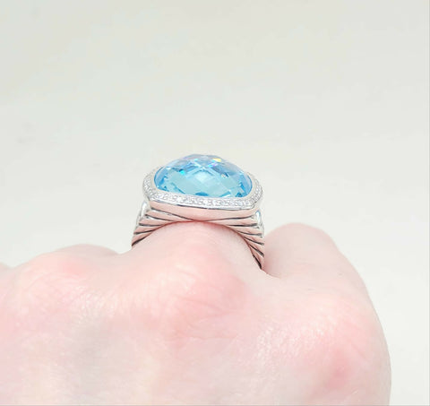Silver ring with a blue gemstone on a neutral background