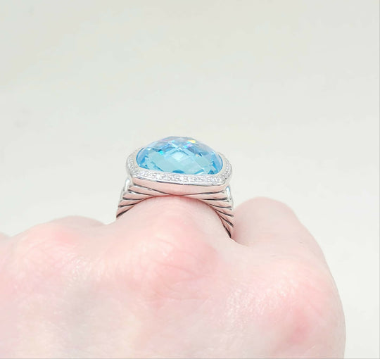 Silver ring with a blue gemstone on a neutral background