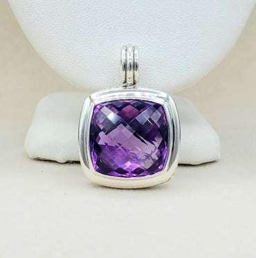 Purple gemstone pendant with silver frame on a white background