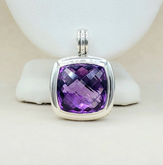 Purple gemstone pendant with silver frame on a white background