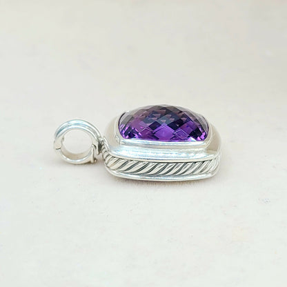 Silver pendant with a purple gemstone on a light gray background