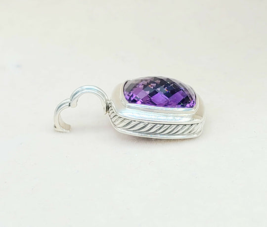 Silver pendant with a purple gemstone on a white background