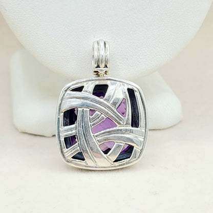 Silver pendant with purple and black inlay on a white background