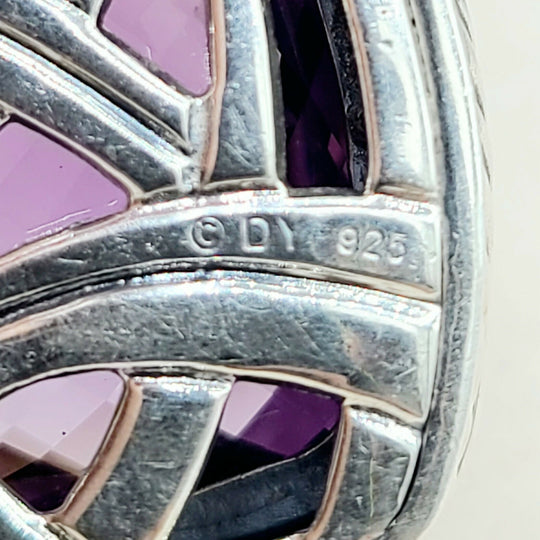 Close-up of silver jewelry with purple stones and visible '925' stamp.