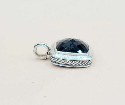 Silver pendant with a blue gemstone on a white background