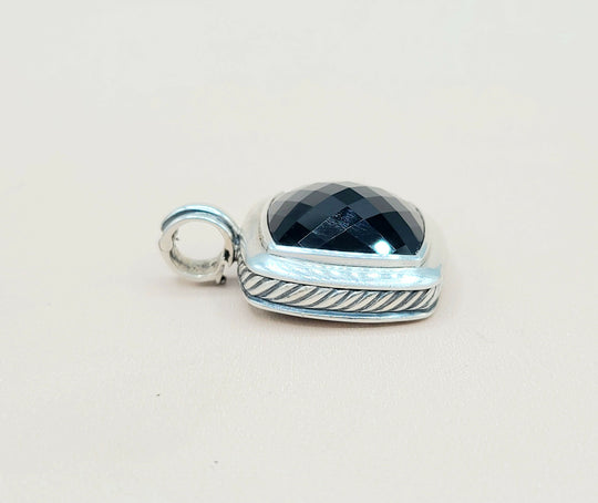 Silver pendant with a blue gemstone on a white background