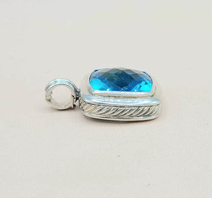 Silver pendant with a blue gemstone on a light gray background