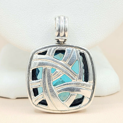 Silver pendant with blue and black inlay on a white background