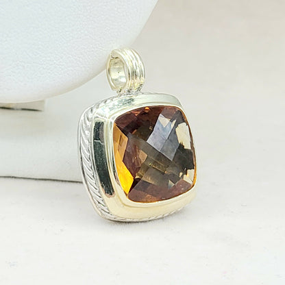 Silver pendant with a brown gemstone on a white background