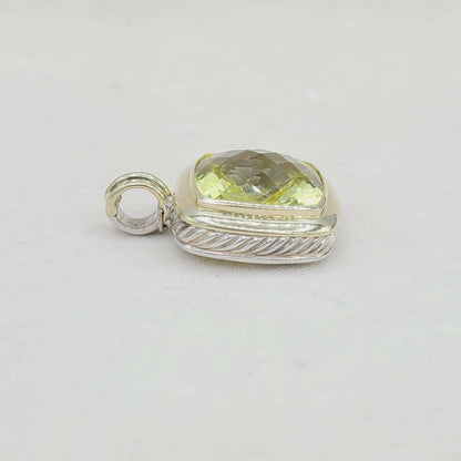 Silver pendant with a yellow gemstone on a light gray background