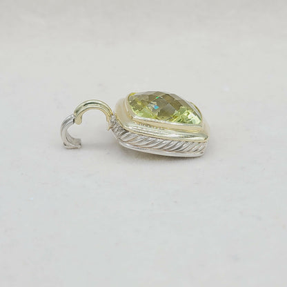 Silver pendant with a green gemstone on a light gray background
