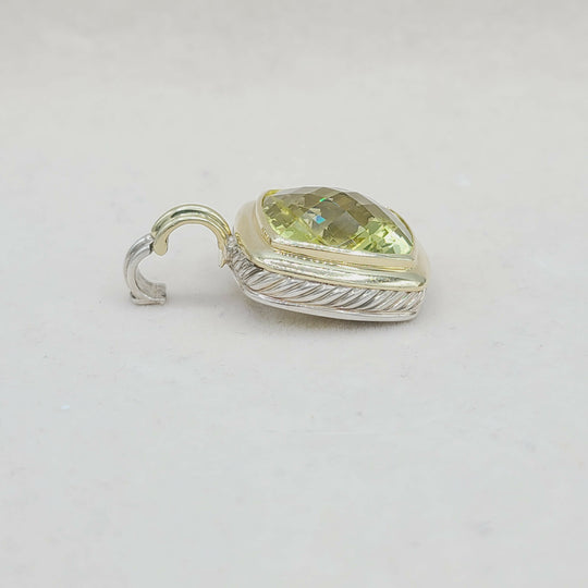 Silver pendant with a green gemstone on a light gray background