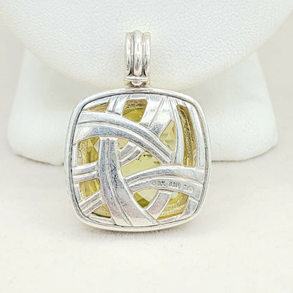 Silver pendant with a yellow center on a white background