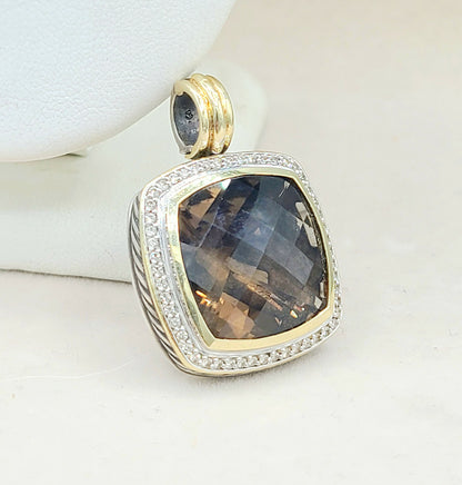 Gold and silver pendant with a smoky gemstone on a white background