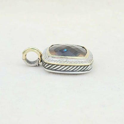 Silver and gold pendant with a gemstone on a white background