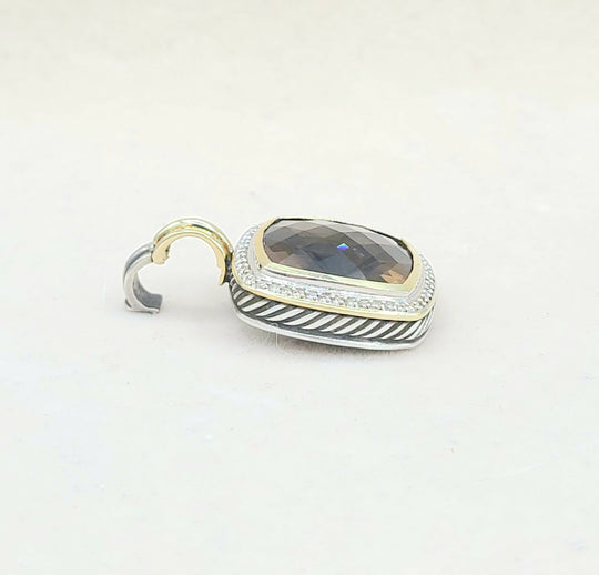 Jewelry pendant with gemstone and gold accents on a light gray background