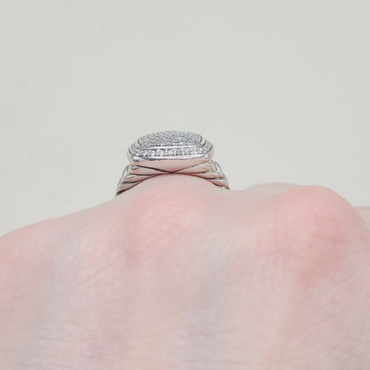 Silver ring with gemstones on a light pink background