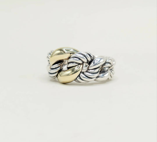 Silver and gold braided ring on a light gray background