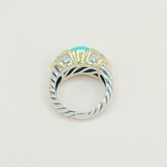 Silver ring with a blue gemstone on a light gray background