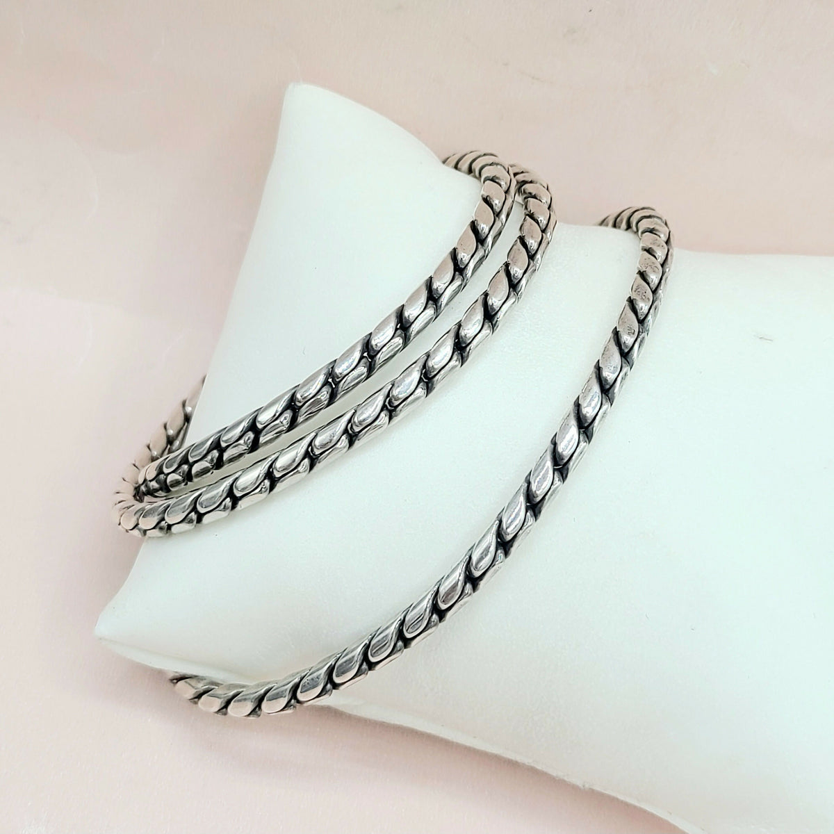 Silver bracelets on a white jewelry display