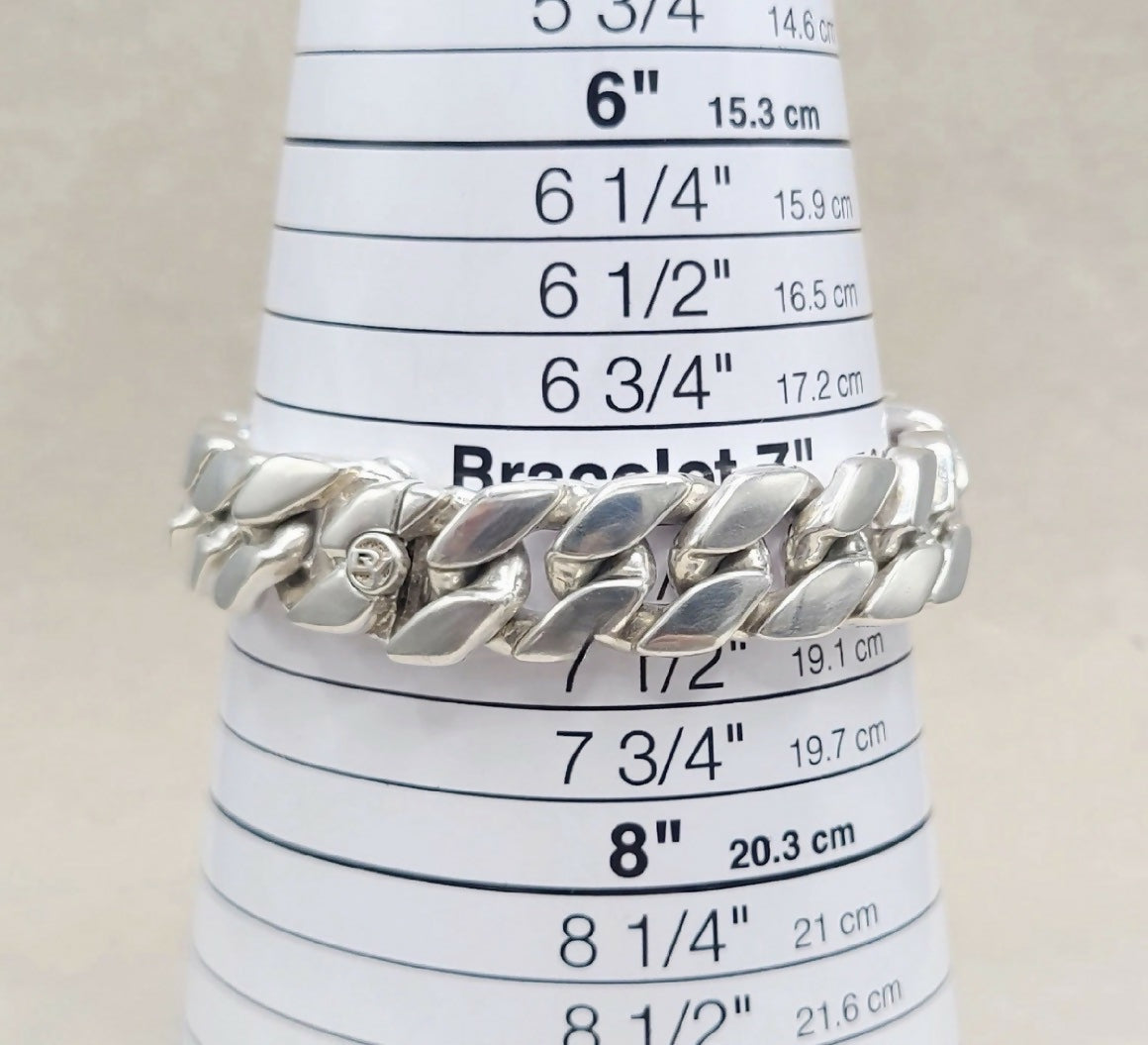 A silver Cuban link chain bracelet displayed on a white cone-shaped ring sizer with printed size measurements.
