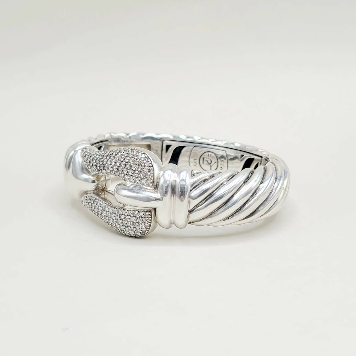 Silver ring with intricate design on a white background