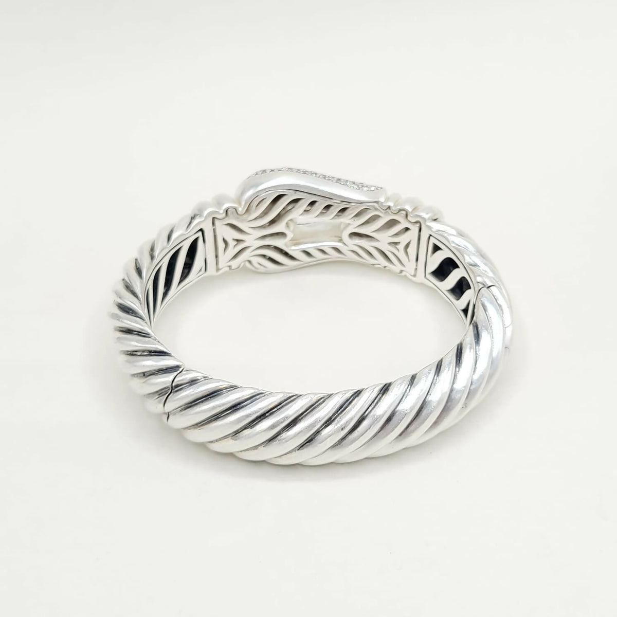 Silver ring with intricate design on a white background