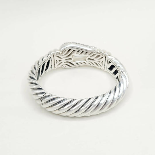 Silver ring with intricate design on a white background