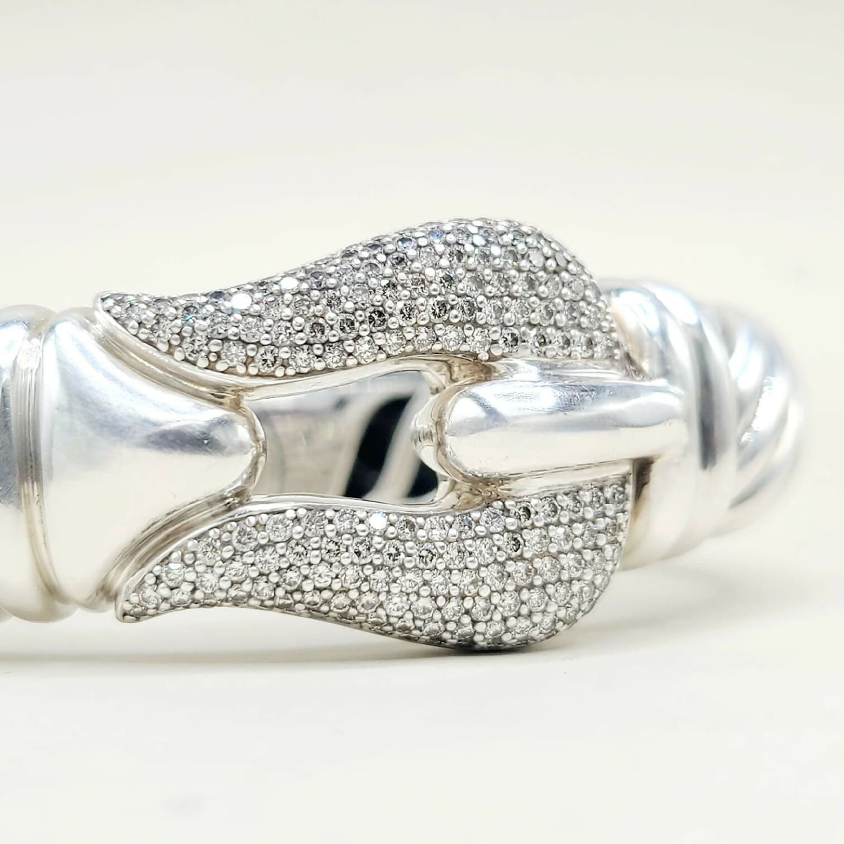 Silver bracelet with diamond accents on a white background