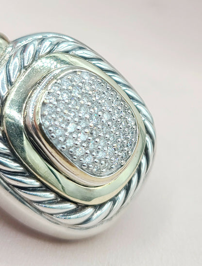 Silver pendant with diamond-studded center on a light pink background