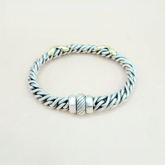 Silver bracelet with braided design on a light beige background