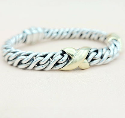 Silver and gold braided ring on a light background