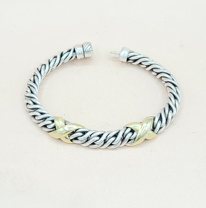 Silver and gold braided bracelet on a light beige background