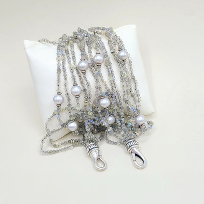 Multi-strand beaded necklace with pearls on a white pillow