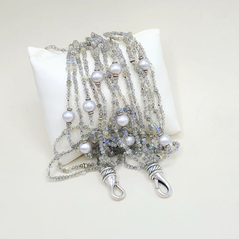 Multi-strand beaded necklace with pearls on a white pillow