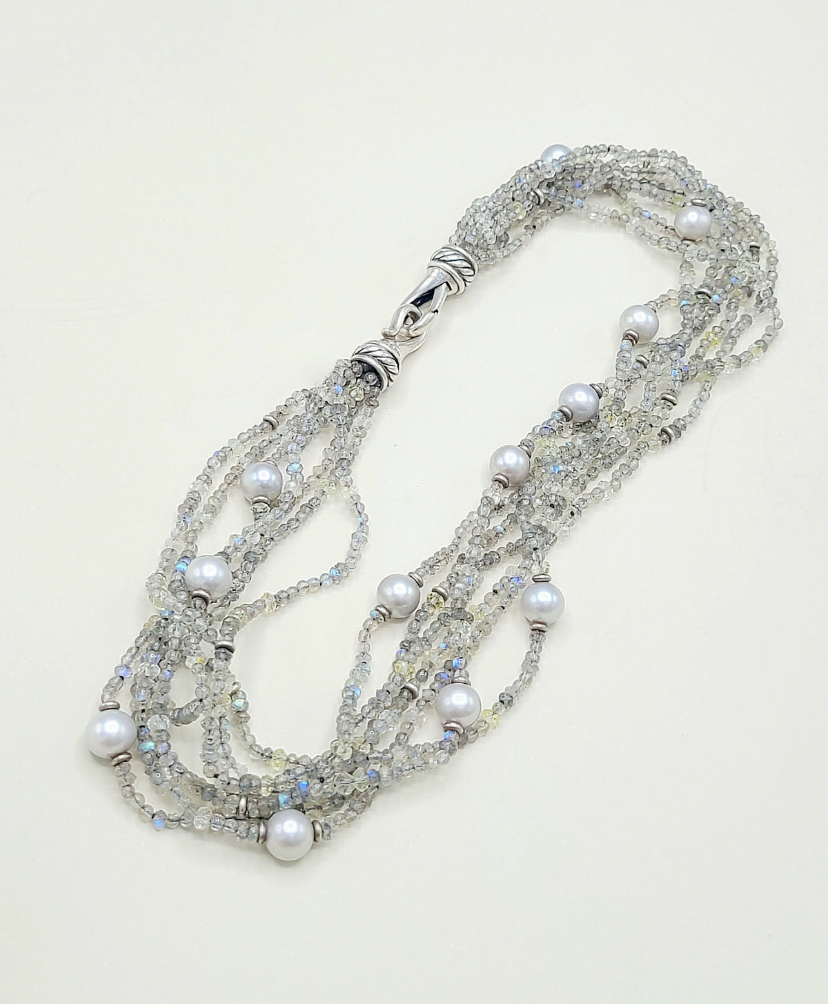 Multi-strand necklace with pearls and crystals on a light background