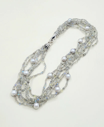Multi-strand necklace with pearls and crystals on a light background