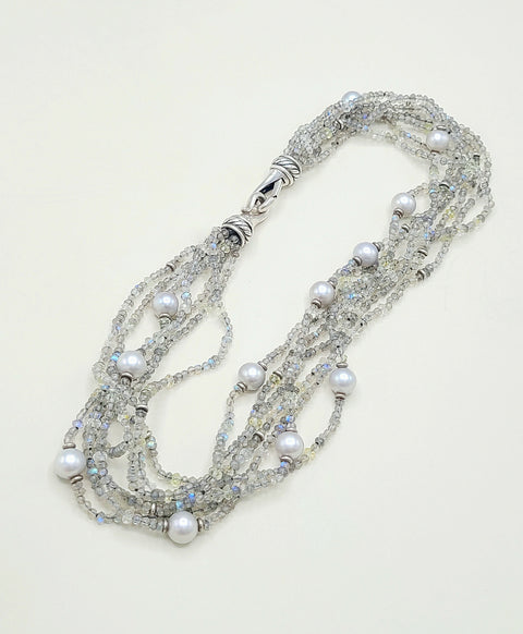 Multi-strand necklace with pearls and crystals on a light background